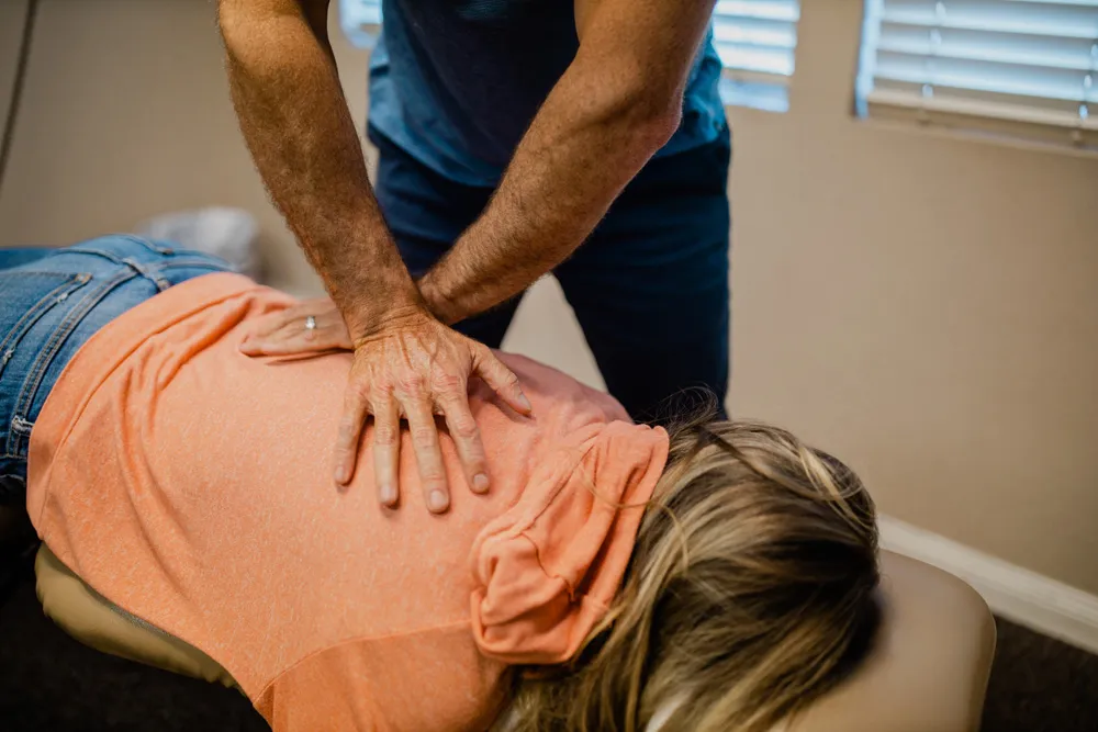 Chiropractor performing a manual spinal adjustment on a patient at a chiropractic practice